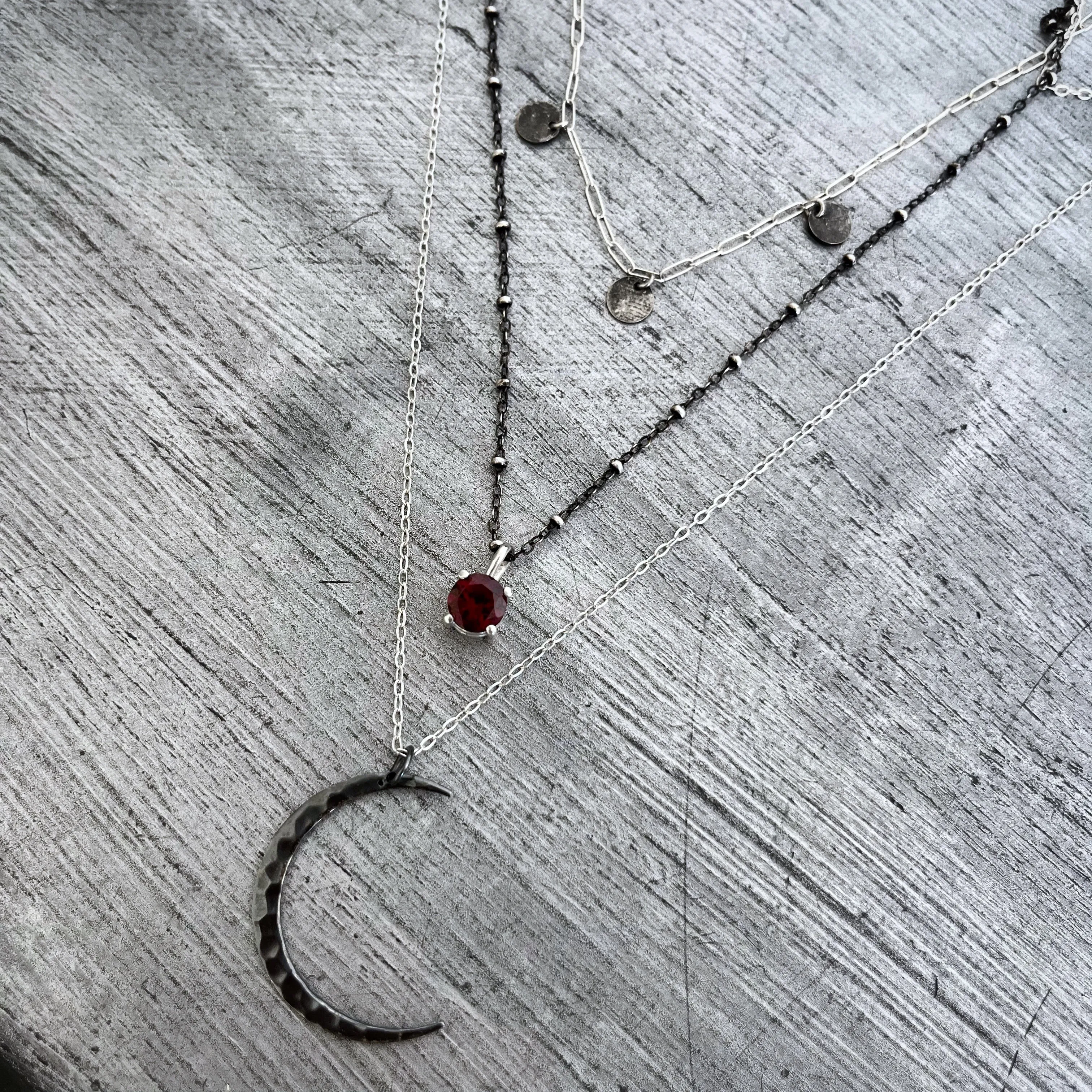 Layered moon necklace set with rhodolite garnet