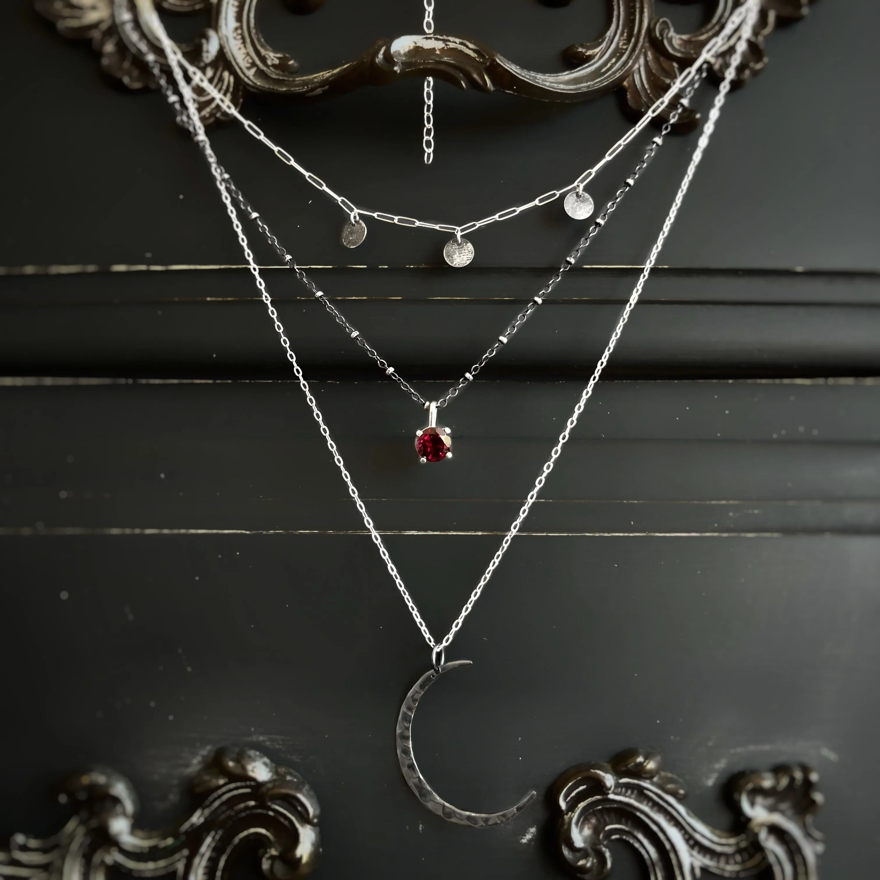 Layered moon necklace set with rhodolite garnet